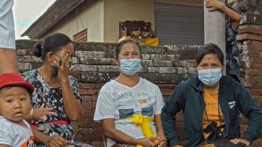 Desa Munggu, Mengwi, Kabupaten Badung, Bali, Endonezya - 26 Eylül 2020: Endonezya 'da maskeli yaşlı insanların yaşadığı küçük bir köy