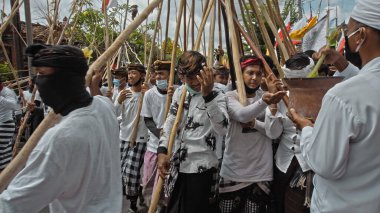 Desa Munggu, Mengwi, Kabupaten Badung, Bali, Endonezya - 26 Eylül 2020: Tören Mekotek. Mekotek, Hindular tarafından yüzyıllardır Bali 'de ilan edilen bir miras. Erkeklerin tuttuğu uzun sopalı bir ayin..