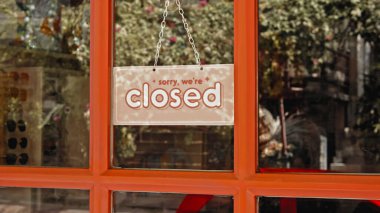 Müessesenin kapısına asılmış bir levha, üzerinde yazı olan cam bir pencere var.