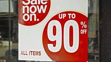 Camda asılı kırmızı yuvarlak tabela ve satışta% 90 indirim var.