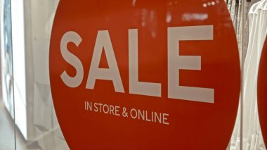 Mağazanın kırmızı pano penceresinde yazıt satışı olan beyaz metin