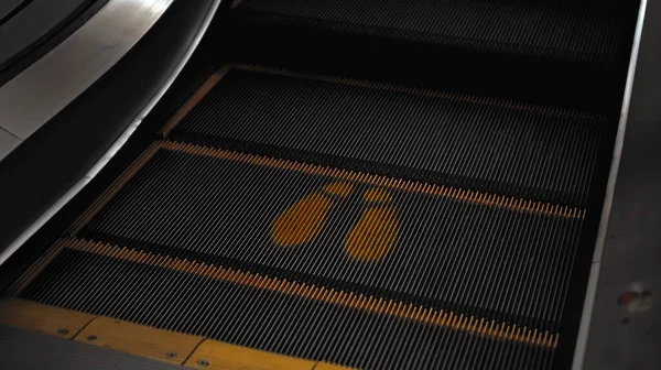 购物中心的黑色楼梯排泄器 带有与他人保持距离的脚印标志 — 图库照片