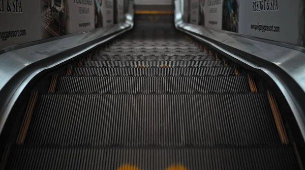 社会的距離を保つための足跡の記号を持つショッピングセンターの黒い階段エスカレーター — ストック写真