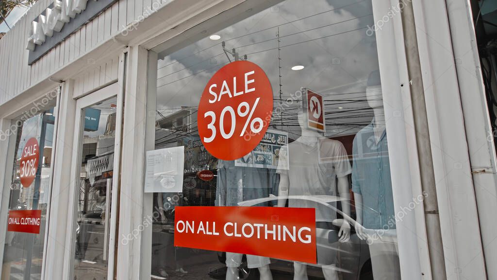 Desa Changgu, Kabupaten Badung, Bali, Indonesia - 7, October 2020: Red round sign hanging on a glass window with the inscription 30% off
