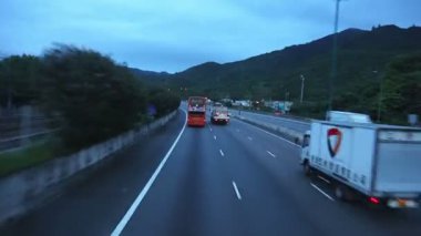 Hong Kong. Chek Lap Kok Havaalanı'na akşam karayolu. Ön camdan ateş. Hızlı hareket