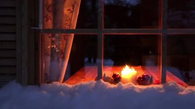 Kışın ahşap ev. İyi geceler. Pencereden Noel mumlar ve topları masada gördüğünüz
