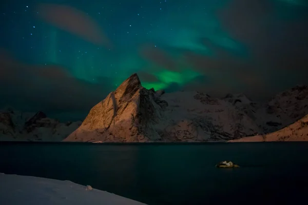 夜ノルウェー 雪をかぶった山々 に囲まれた冬のフィヨルド オーロラと雲 — ストック写真
