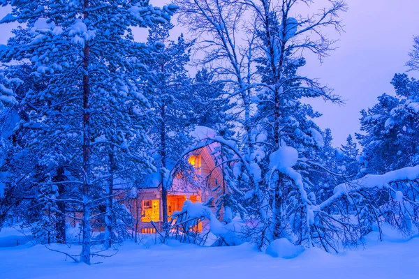 芬兰拉普兰的冬天 在茂密的傍晚森林中 一座孤寂的小屋的光芒 很多雪 — 图库照片