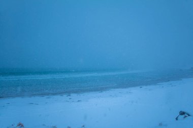 Kış plaj. Yoğun kar yağışı ufuk gizler. En düşük görünürlük