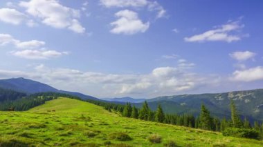 Ağaçlık yaz dağlar. Güneşli bir gün. Glade ile yeşil çim. Bulutlar hızlı koş. Zaman atlamalı