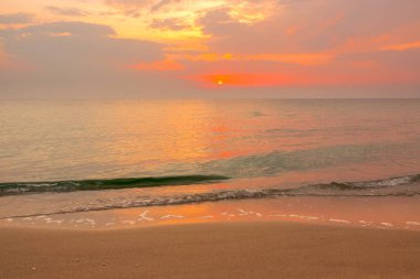 Yeşil dalga üzerinde turuncu günbatımı