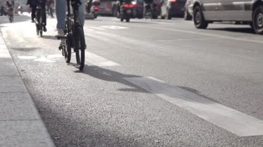 Güneşli havalarda şehir Sokağı. Araba trafiği. Tanınmayan bisikletçiler bisiklet yolu boyunca binmek. Yavaş hareket