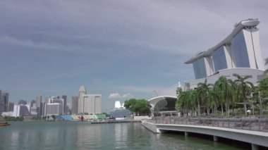 Singapur günü. Marina Bay ve palmiye ağaçları ile yaya alanı. Hızlı hareket