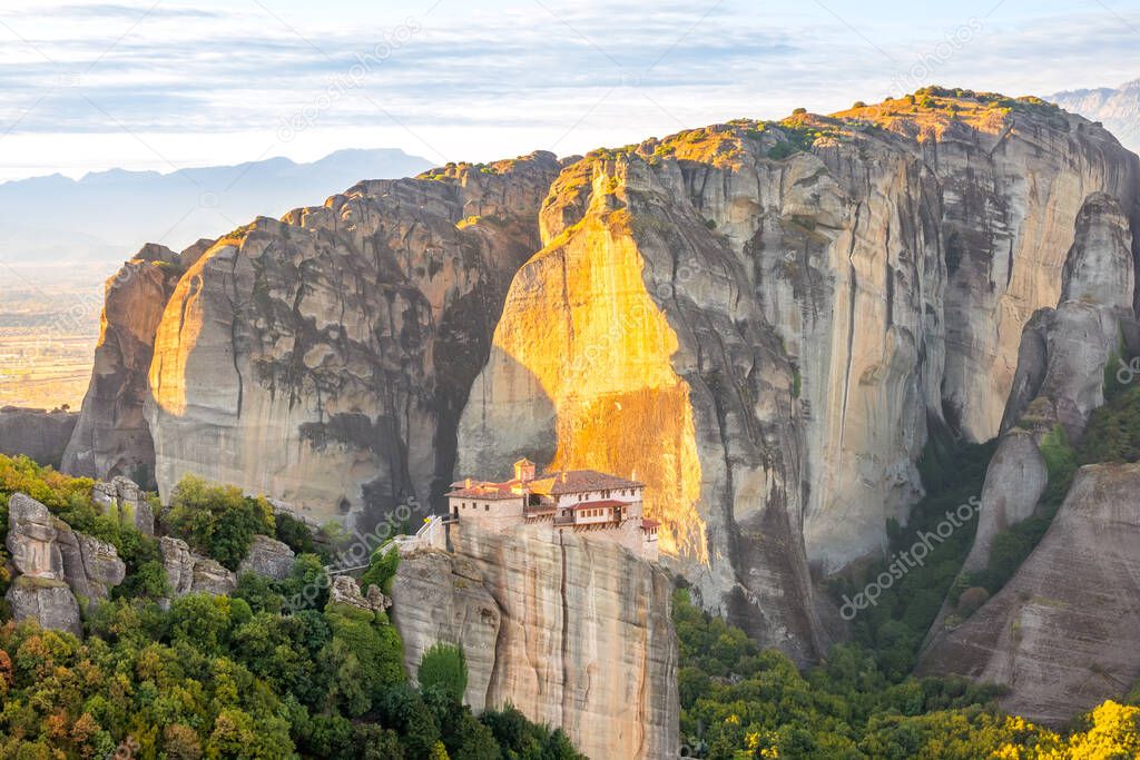 Greece. Sunny summer evening in a mountain valley. A stone monastery on top of a cliff