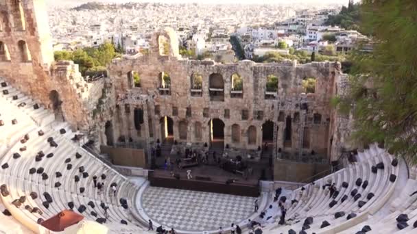 ギリシャだ アテネの夏の夜 古代アンフィテアター オデオン ヘロデス アッティカス 舞台上や講堂の石のベンチで現代的なコンサートの準備 — ストック動画
