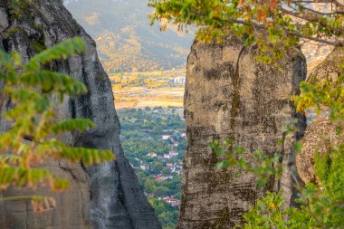 Yunanistan. Kalambaka 'da yaz güneşli bir gün. Vadideki kırmızı çatılı evlere kayaların arasından bak.