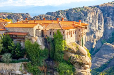 Yunanistan. Meteora 'da açık bir yaz günü. Büyük kayalara karşı kırmızı çatıları olan birkaç kaya manastırı.