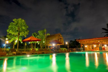 Endonezya 'da. Ormanda bir gece. Otelde boş havuz ve su barı var.