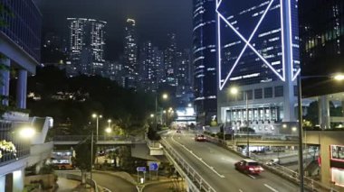 Gece Hong Kong. Gökdelenler arasında büyük bir trafik kavşağı. Araba trafiği. Hızlı hareket