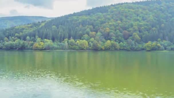 湖面的水面在森林覆盖的群山之间 阴云密布旋转时间的流逝 — 图库视频影像