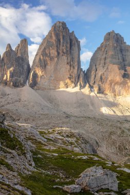 İtalyan Dolomitleri 'nde güneşli bir yaz günü. Bulutların gölgesinde mavi gökyüzüne karşı Tre Cime di Lavaredo