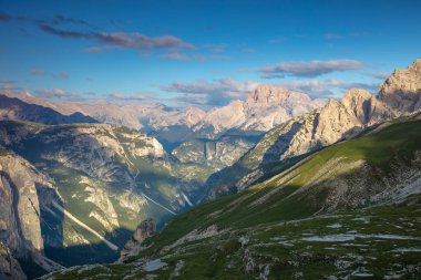 İtalyan Dolomitleri 'nde güneşli bir yaz günü. Kaya ve yeşil tepeler Işık bulutlarından gölgeler