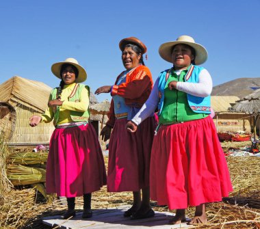 Uros Adaları, Peru - Haziran 25, 2019 - Puno yakınlarındaki Uros Adaları birinde uros kadınlar, Peru. Adalar insan yapımı kil ve totoro sazlıkları ve Bolivya sınırı yakınındaki Titicaca Gölü üzerinde yüzer..