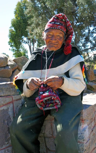Taquile Adası, Titicaca Gölü, Peru - 25 Haziran 2019 - Taquile Adası'nın yaşlı yerli sikulu geleneksel bir şapka örer. Taquile Adası'nda, erkekler örgü örer ve kadınlar örer..