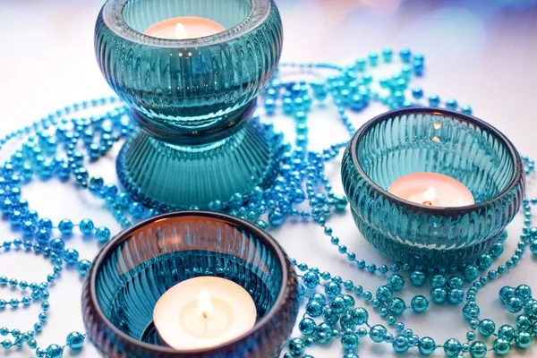 Turkuaz şamdanlar üç yanan mumlar topları, şeklinde Noel çelenk ile beyaz bir arka plan üzerinde yukarıdan vurdu