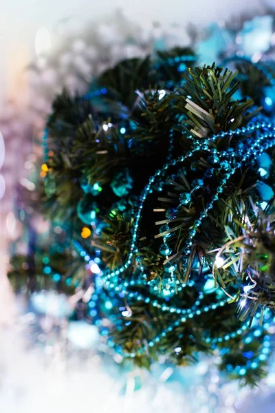 Turkuaz çelenk, tinsel, parlayan ışıklar ve yapay kar ile dekore edilmiş Noel ağacının üstten görünüm.