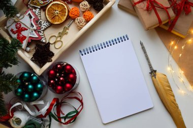 Bir dikdörtgen beyaz dizüstü Noel tarafından çevrili beyaz bir arka plan üzerinde yatıyor ve yeni yıl önemsiz