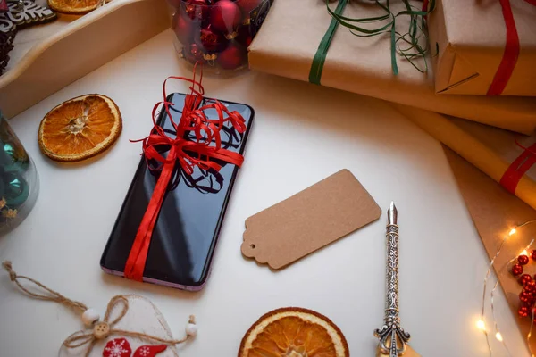 Мобильный Смартфон Красной Лентой Окружении Подарков Других Рождественских Мелочей — стоковое фото