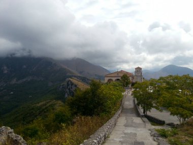 Katolik Kilisesi dağ, Maratea, Basilicata, Potenza, İtalya üstüne giden asfalt yol üzerinde bulutlu gökyüzü bulutlu