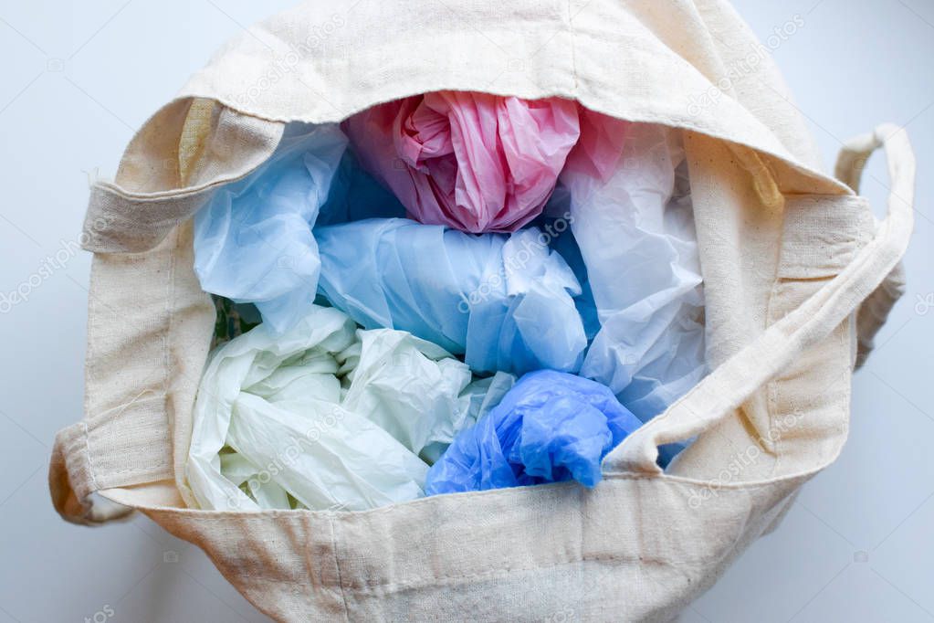 Multi-colored blue, red, white plastic bags in a rag cotton bag