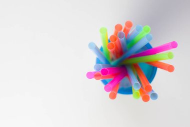 Beyaz bir arka plan, metin eklemek için boş bir yer üzerinde mavi bir cam parlak çok renkli plastik tübüllerin