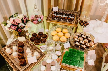 Kek, kek, şeker, şeker, açık büfe. Düğün ziyafeti alanı için tatlı masası. Kapatın. Çikolata. Madalyalı lezzetli..