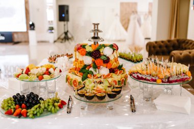 Taze, egzotik, organik meyveler, açık büfe masasında hafif atıştırmalıklar. Mini yemekler, abur cuburlar, etkinliklerde restoran yemekleri. Parti malzemeleri için süslenmiş nefis bir masa..