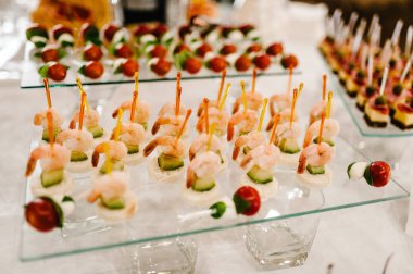 Tablo üzerinde çeşitli mini kanepeler. Event'de Restoran yiyecek. Lezzetler ve aperatifler büfe masa üzerinde. Deniz ürünleri. Gala resepsiyonu. Ikram Servisi.