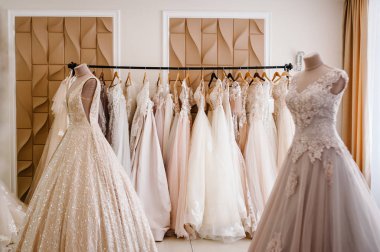 Ürün yelpazesine bir askı arka plan stüdyo üzerinde asılı elbiseler. Moda düğün trendleri. Düğün salonu iç.