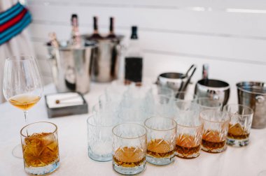 Viski, viski, viski, birçok bardak brendi masa servis buz küpleri ile. Vintage bardak dolu viski, konyak, şarap.