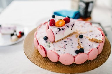 Pembe kek dekore edilmiş taze çilek ile Doğum kesmek: çilek, ahududu, kuş üzümü, böğürtlen, yaban mersini ve macarons tatil için. Üstten görünüm.