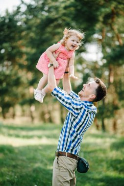 Babası atar ve kızı doğa üzerine yaz gün tatile döner. Baba ve kız parkta günbatımı anda oynamak. Uçan kız. Dostu aile kavramı. Portre.