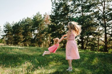 Neşeli Anne kızı Park ellerinde günbatımında iplik 