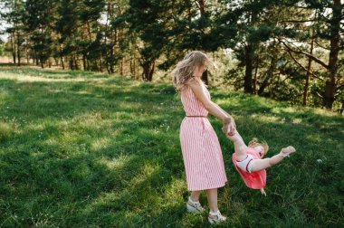 Neşeli Anne kızı Park ellerinde günbatımında iplik 