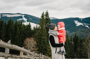 Genç Anne kızı sıcak giysiler karlı dağlarda dinlenme ile