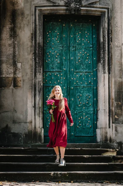 Молода Жінка Стильній Червоній Сукні Букетом Рожевих Троянд Позує Сходах — стокове фото