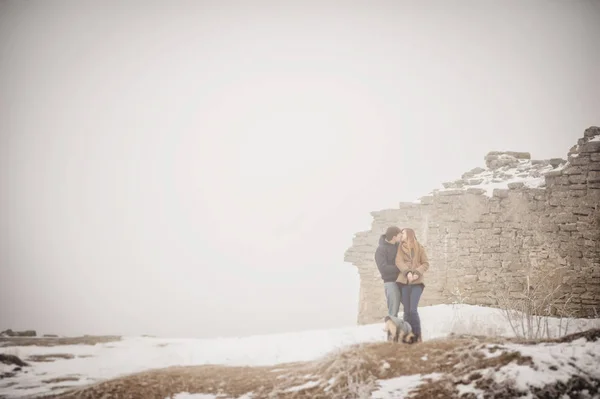 可爱的夫妇走在老城堡废墟在下雪的冬日 — 图库照片