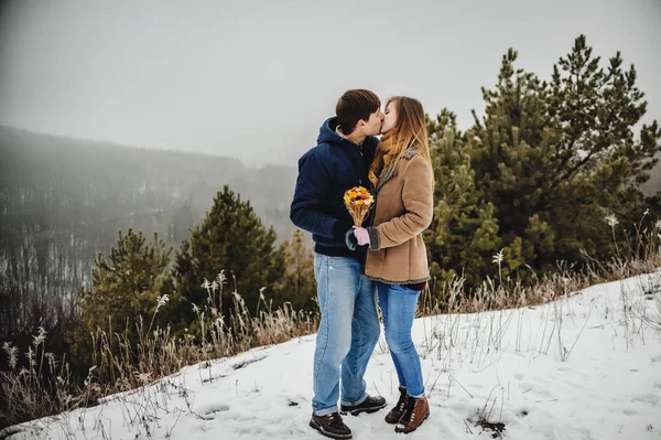 男と女を抱き締めると 冬の風景の中でキス — ストック写真