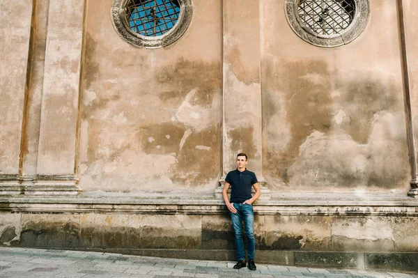 Brunet delikanlı eski duvarda poz portresi