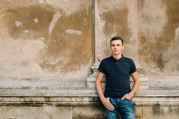 Brunet delikanlı eski duvarda poz portresi